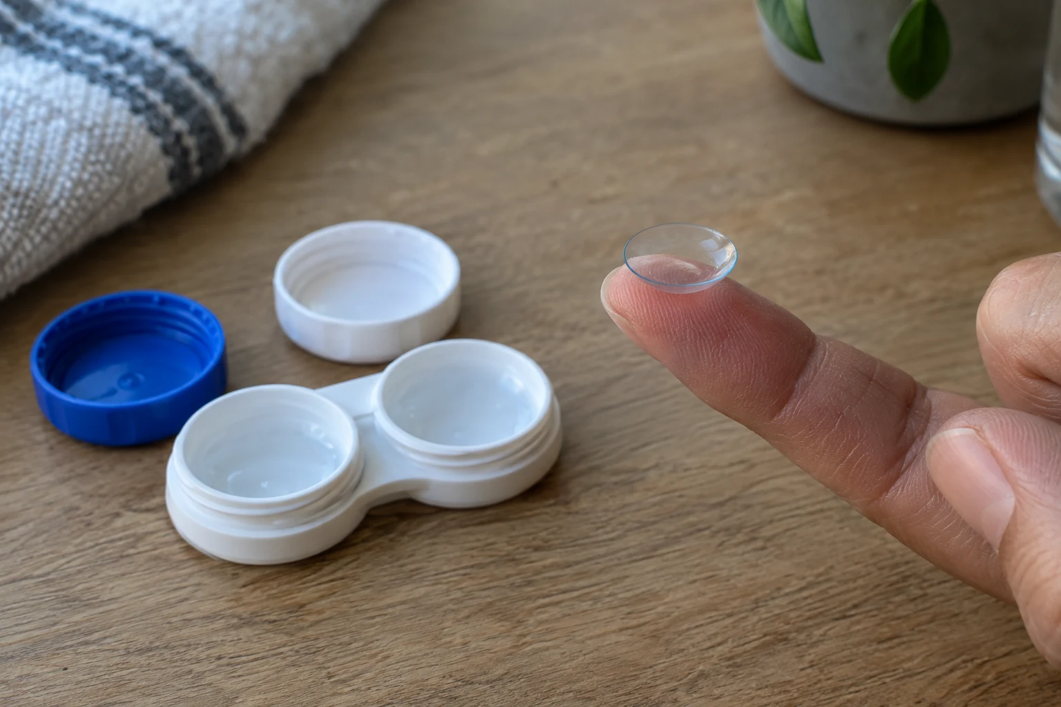 Parmak ucundaki kontakt lens ve lens kabı